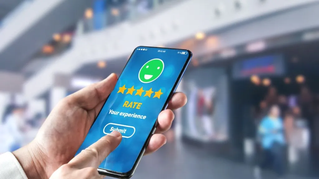 Person rating hotel with five stars on a smartphone app.