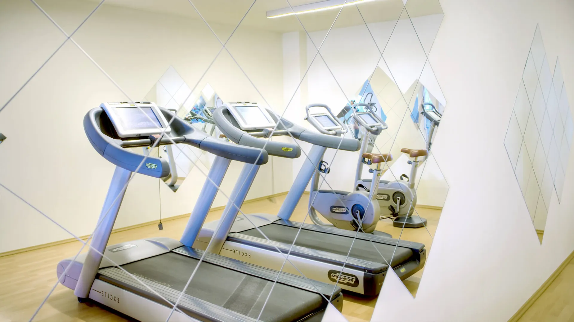 Modern gym with treadmills and exercise equipment in a hotel.