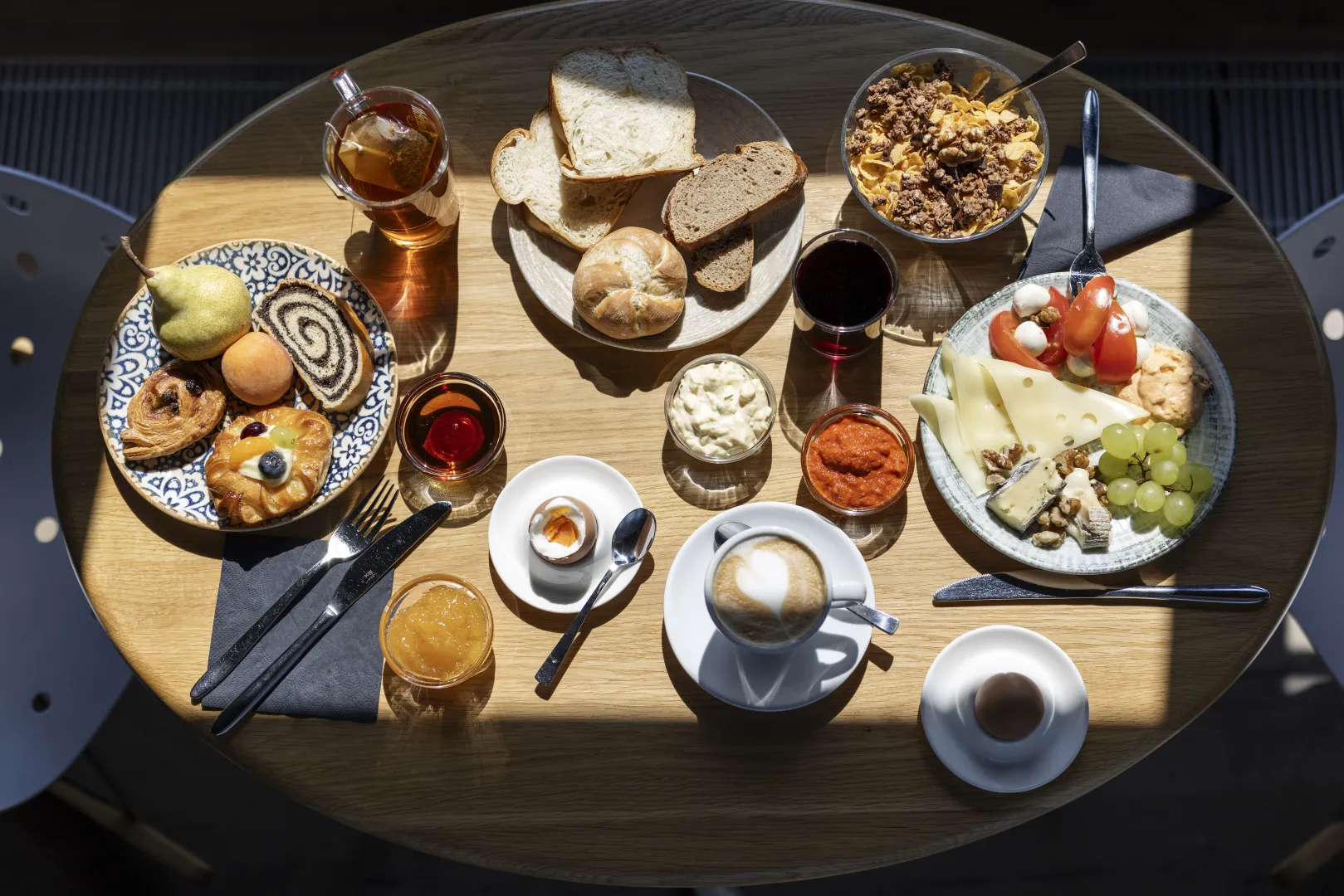 Abundant breakfast buffet with pastries, cheese, fruit, and coffee.