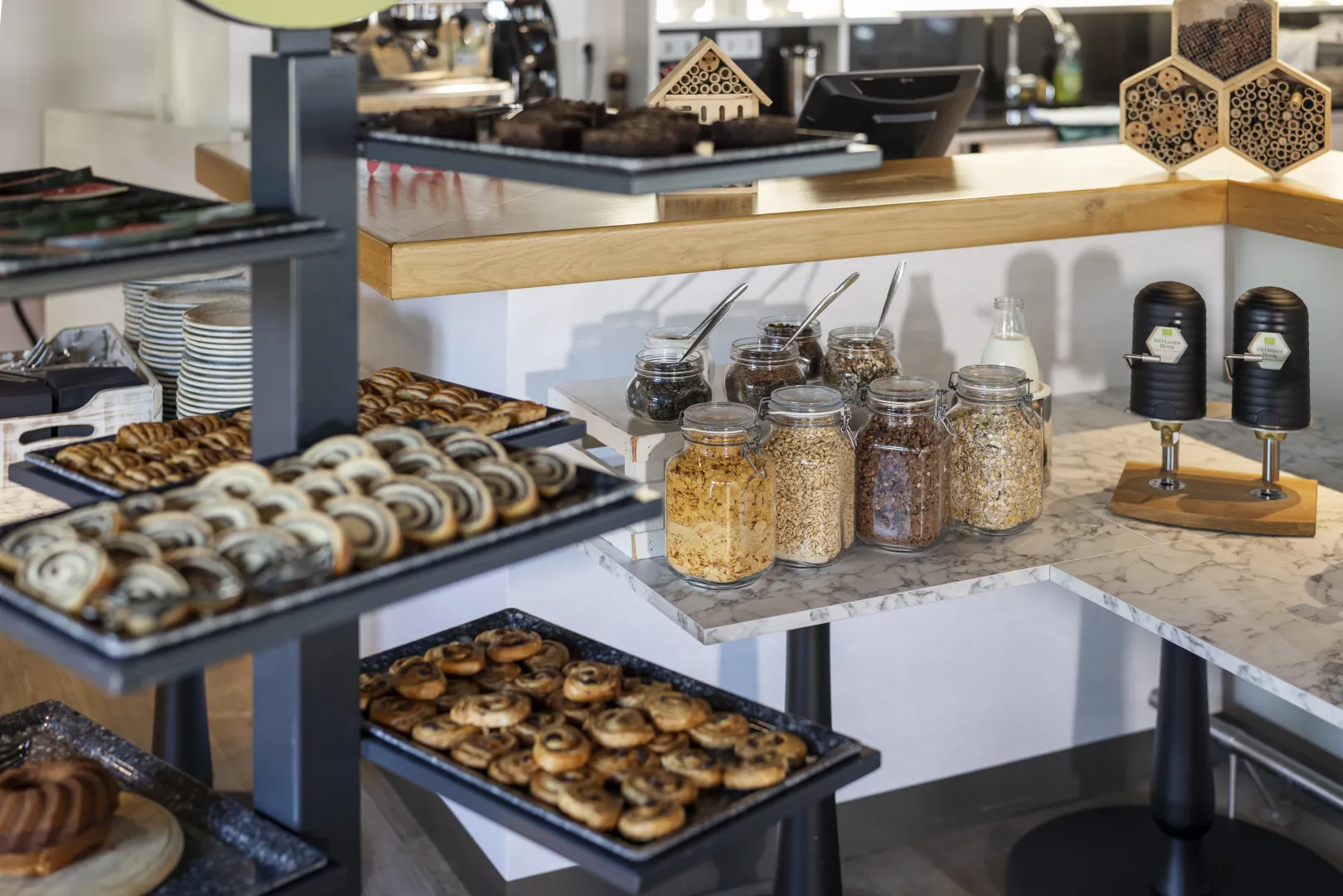 Breakfast buffet with pastries and cereals in a modern hotel restaurant.