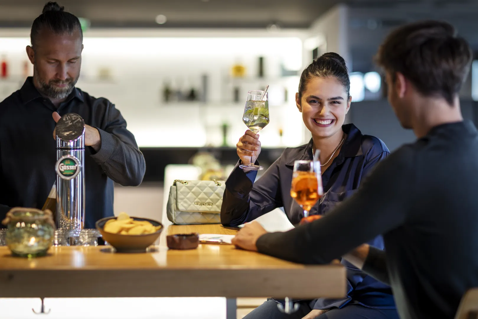 Guests enjoying drinks at the hotel bar with a cheerful atmosphere.