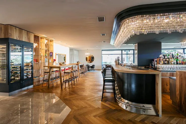 Stilvolle Hotelbar mit modernen Holzmöbeln und elegantem Beleuchtungskonzept.