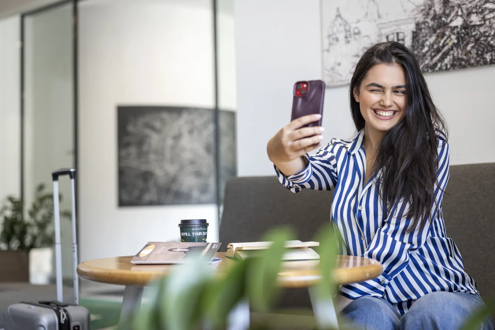 Woman smiling and taking a selfie in the hotel lobby.